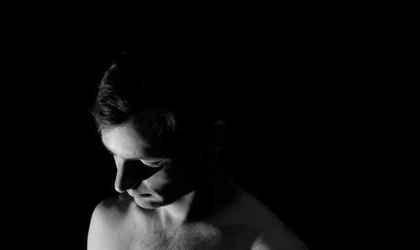 černobílý foto portrét chlapa, v dramatickém osvětlení  - Fotografie, Obrázek