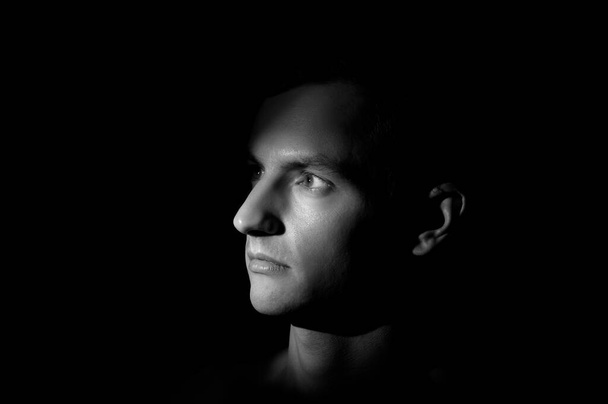 dramatic portrait of a man on black background - Foto, afbeelding