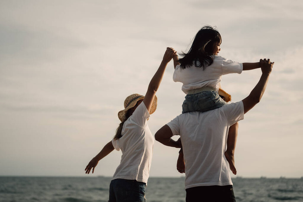 Щаслива азіатська сім'я подорожує разом на пляжі. Сім'я з подорожами на пляж. Люди насолоджуються відпусткою. Фотографія високої якості - Фото, зображення