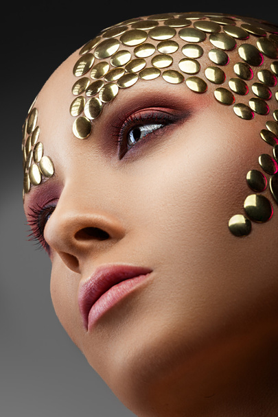 Woman with golden applique - Фото, изображение