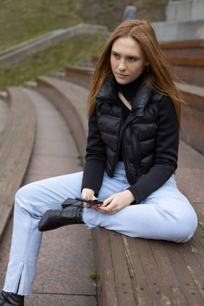 Ragazza adolescente sconvolta con smartphone seduto sulle scale all'aperto.  - Foto, immagini