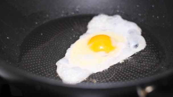 Huevos revueltos, tortilla en una sartén caliente con aceite caliente. Un desayuno rápido y saludable. Alimentación saludable. - Metraje, vídeo