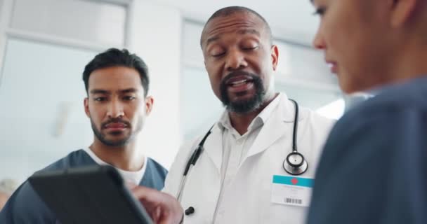 Tablet, nurses and doctor talking in hospital, discussing research or medical records. Wellness, digital tech and group of physicians, men and women chatting about online healthcare results in clinic. - Video