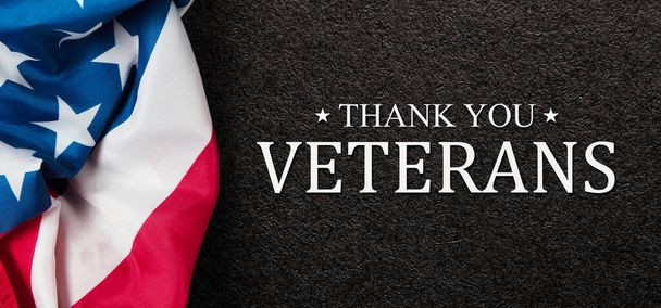 Closeup of American flag with Text Thank You Veterans on black textured background. American holiday banner. - Zdjęcie, obraz