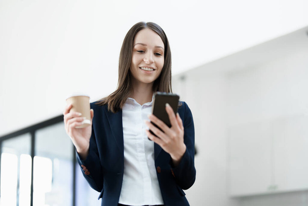 Donna d'affari eccitata utilizzando il telefono cellulare mentre in ufficio, concetti di business - Foto, immagini