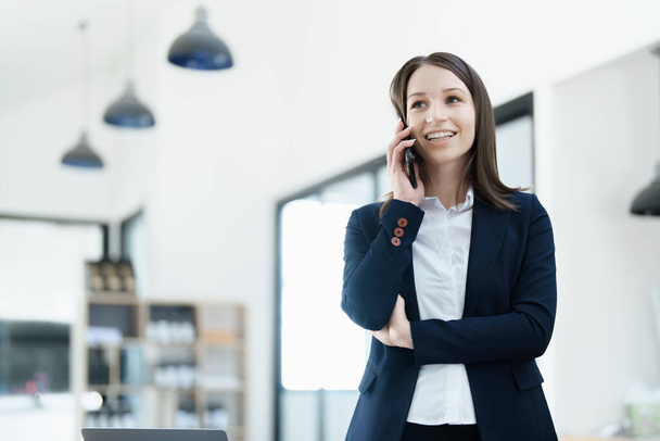 владелец бизнеса или азиатские женщины-маркетологи используют бизнес-телефоны в офисной работе. - Фото, изображение