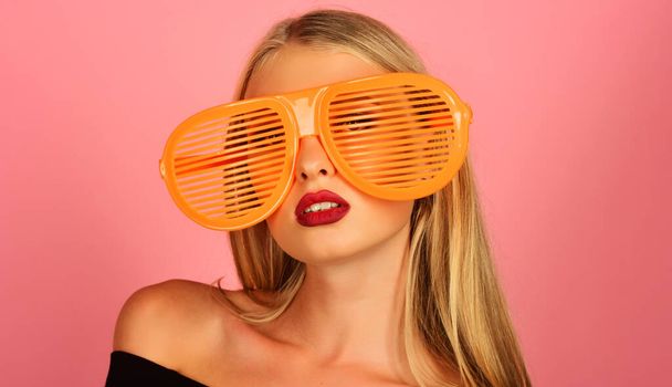 Stylish model in shutter shade sunglasses. Fashion portrait of woman in glamour striped glasses. Sexy beautiful blonde woman with bare shoulders, long hair, bright makeup. Summer. Travel and vacation - Photo, Image