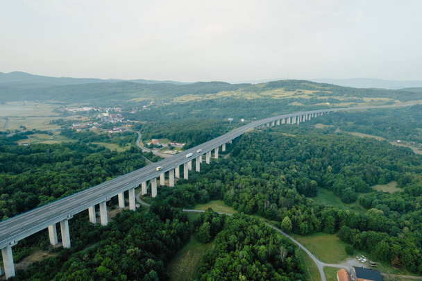 Transport bridge in mountainous area, road and trees. A panoramic view of nature from above. - Foto, Imagen