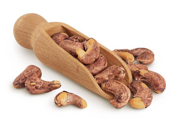 tas de noix de cajou avec coquille dans une cuillère en bois isolé sur fond blanc. - Photo, image