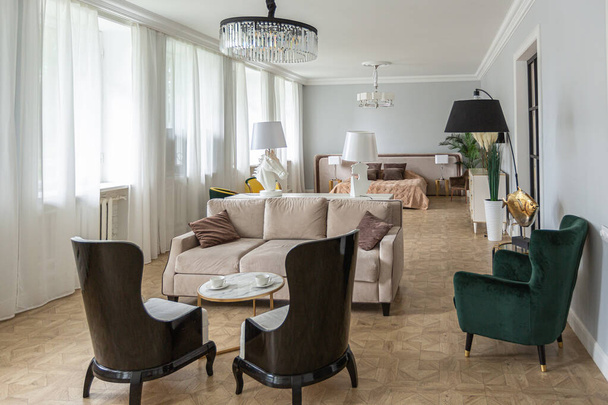 Luxus-Interieur einer modernen Wohnung in hellen Farben mit stilvollen Möbeln. Küche, Schlaf- und Wohnbereich ohne Wände. - Foto, Bild