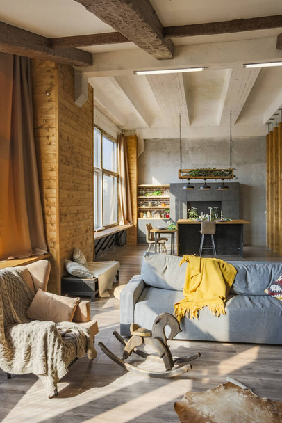 Dark loft style interior of big cozy country house. open plan apartment with kitchen area, rest zone and bed area. Huge windows and wooden decoration - Foto, Imagen