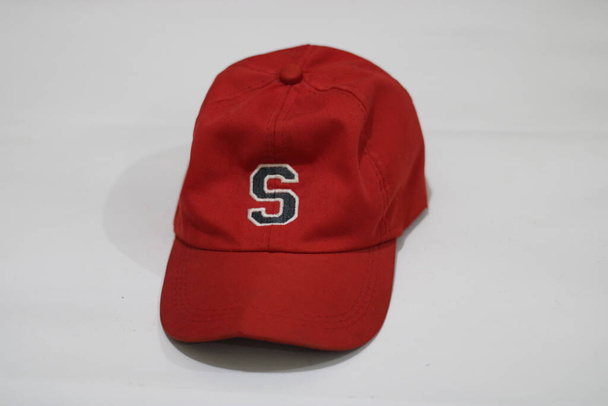 白い背景に濃い赤の帽子の写真 - 写真・画像