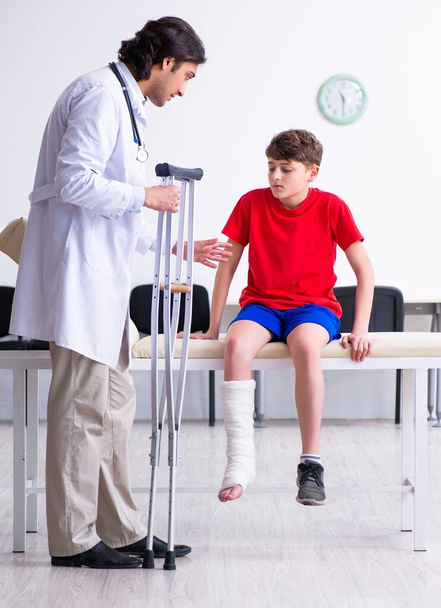 The leg injured boy visiting young doctor traumatologist - Photo, Image
