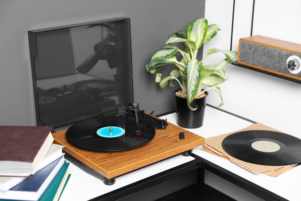Stylish turntable with vinyl disc near grey wall in room - Fotoğraf, Görsel
