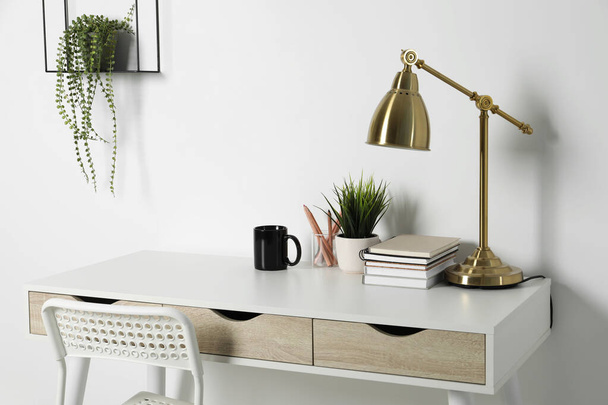 Comfortable workplace with white desk near wall - Foto, Bild