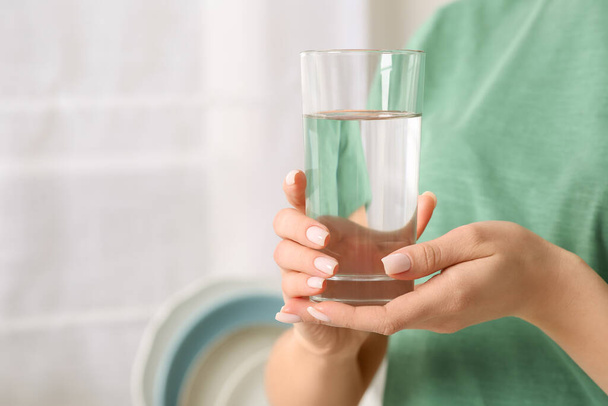 Hábito saudável. Fechar-se de mulher segurando vidro com água doce dentro de casa, espaço para texto - Foto, Imagem