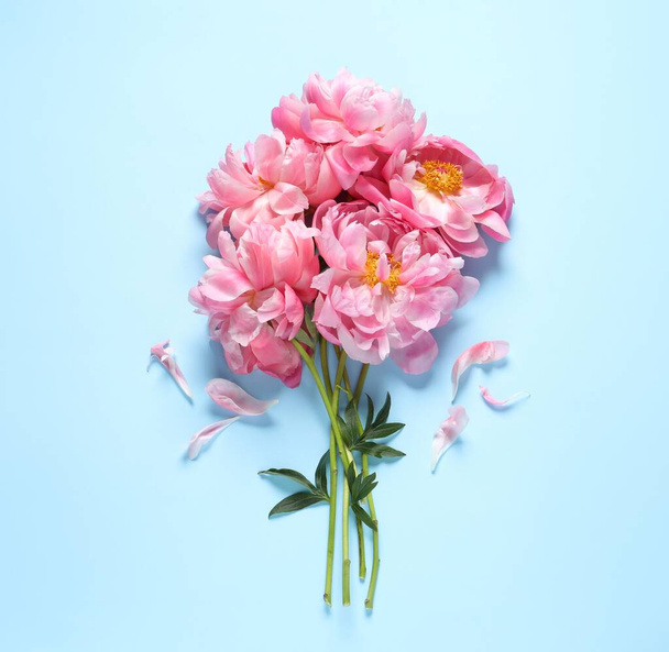 Bunch of beautiful pink peonies and petals on light turquoise background, flat lay - Foto, Bild