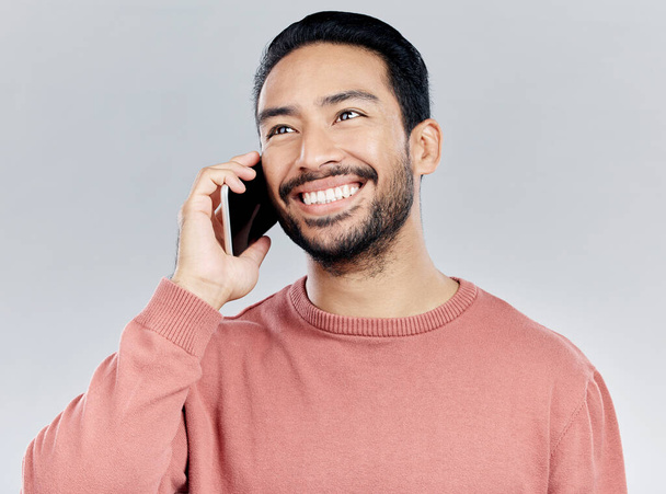 Happy, young asian man and phone call in studio for communication, networking and white background. Student male model, smartphone and excited smile for chat, listening and talking with happiness. - Foto, imagen