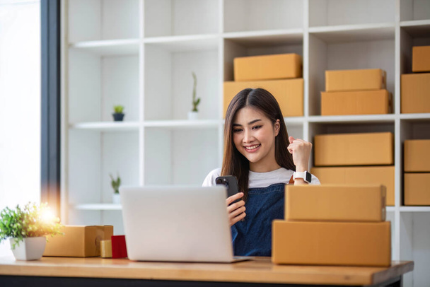 Starting Small business entrepreneur SME freelance, Portrait young woman working at home office, BOX, smartphone, laptop, online, marketing, packaging, delivery, b2b, SME, e-commerce concept - Photo, Image