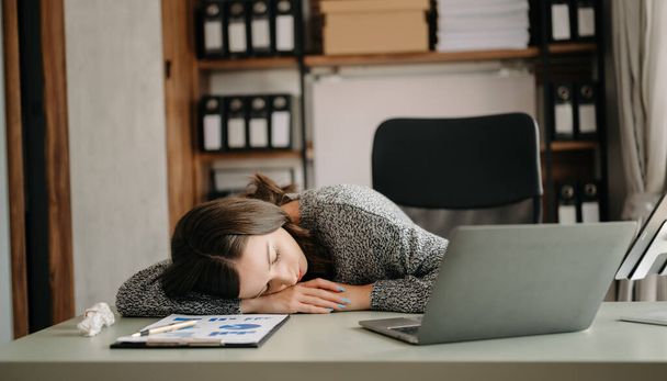 Businesswoman is sleeping, bored, and overthinking from working at the modern office - Valokuva, kuva