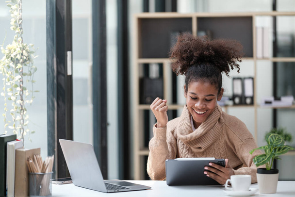 Ofiste bilgisayar telefonu ve tabletle çalışan Amerikalı Afrikalı Kadın. Yüksek kalite fotoğraf - Fotoğraf, Görsel