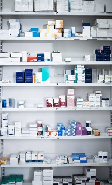 Ως κορυφαίο φαρμακείο, αποθηκεύουμε μόνο τα καλύτερα. ράφια γεμάτα με διάφορα φαρμακευτικά προϊόντα σε φαρμακείο - Φωτογραφία, εικόνα