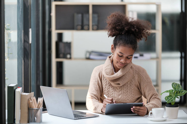 American African Woman pracuje v kanceláři s počítačem a Tabletem. Kvalitní fotografie - Fotografie, Obrázek