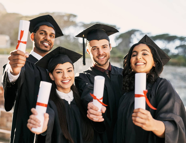 Mirando hacia un futuro nuevo y brillante. Retrato de un grupo de estudiantes celebrando con sus diplomas el día de la graduación - Foto, imagen