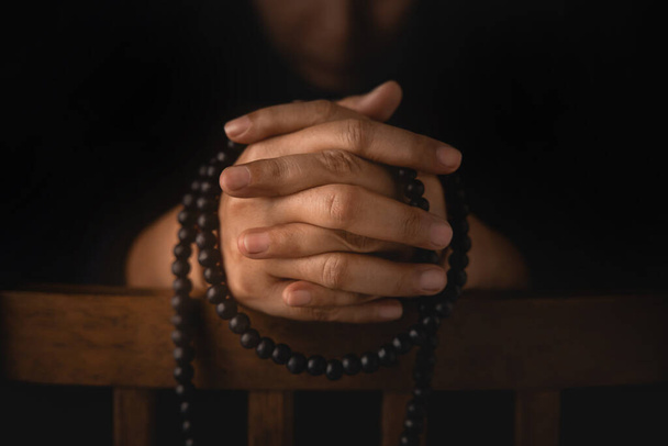 Spirituality, Religion and Hope Concept. Stressed Person Praying by Bead. Way to Practicing Mind and Mental Health. Supplication, Believe and Faith for Human. Dark Tone - Zdjęcie, obraz