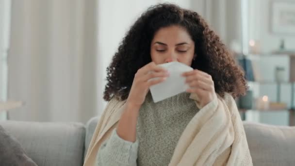 Sick, blowing nose and woman in a home living room with illness and tissue for virus and covid. Sofa, lounge and sinus problem of a mixed race female with allergies, flu and sneezing issue in a house. - Footage, Video