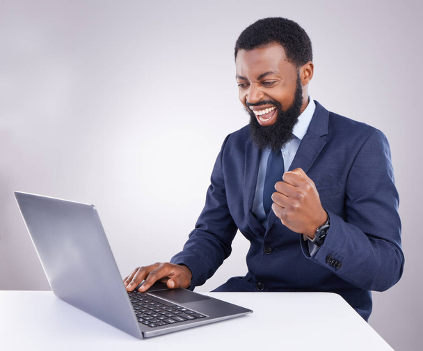 Győztes fekete férfi laptop elszigetelt fehér háttér tőzsde, kereskedelmi siker vagy üzleti bónusz és ököl szivattyú. Igen, győztes és személy ünnepli értékesítés, nyereség vagy célok számítógépen stúdióban. - Fotó, kép