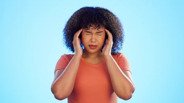 Dolor de cabeza, dolor y cara de mujer sobre fondo azul con estrés, niebla cerebral y vértigo. Mujer enferma modelo masaje templo para migraña, fatiga y salud mental ansiedad de trauma psicología en estudio. - Imágenes, Vídeo
