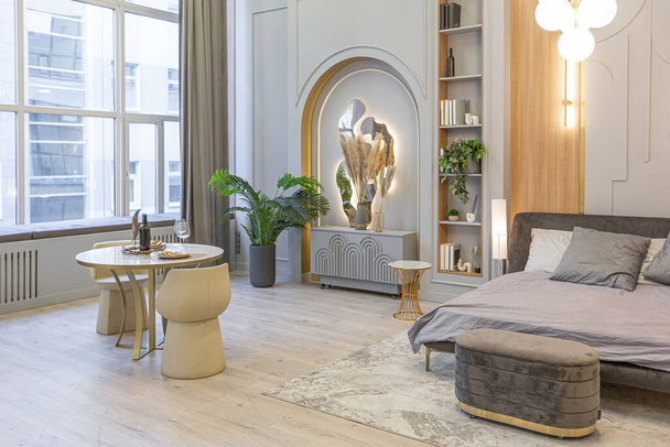 stijlvol luxe interieur van modern studio appartement in groene pastelkleuren met houten elementen. dure meubels en decoraties - Foto, afbeelding