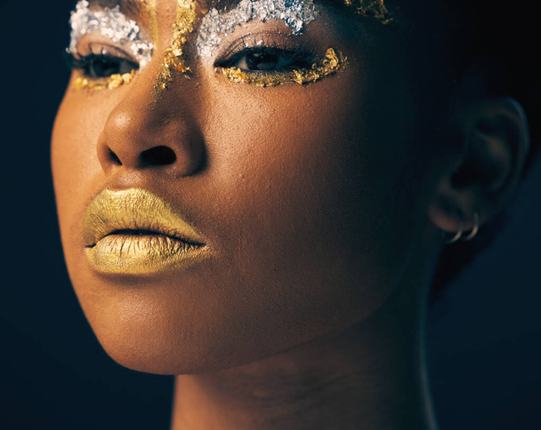 Beauty, gold and face with black woman and makeup in studio for luxury, cosmetics and African pride. Natural, creative and goddess with female model on background for queen, bronze and glamour. - Foto, Imagen
