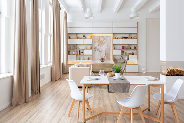 sisustus tilava valoisa yksiö skandinaaviseen tyyliin ja lämmin pastelli valkoinen ja beige värejä. trendikkäitä huonekaluja olohuoneessa ja moderni yksityiskohtia keittiössä. - Valokuva, kuva