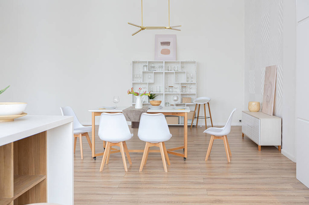 interior design spacious bright studio apartment in Scandinavian style and warm pastel white and beige colors. trendy furniture in the living area and modern details in the kitchen area. - Foto, immagini