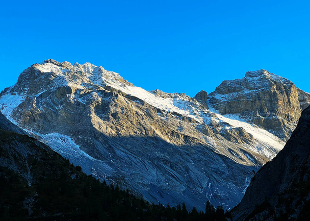 Skalnaté vrcholy Plattenflue (3012 m) a Hoch Ducan nebo Piz Ducan (3063 m) v pohoří Ducankette a ve švýcarských Alpách, Davos - Kanton Grisons, Švýcarsko (Kanton Graubuenden, Schweiz) - Fotografie, Obrázek