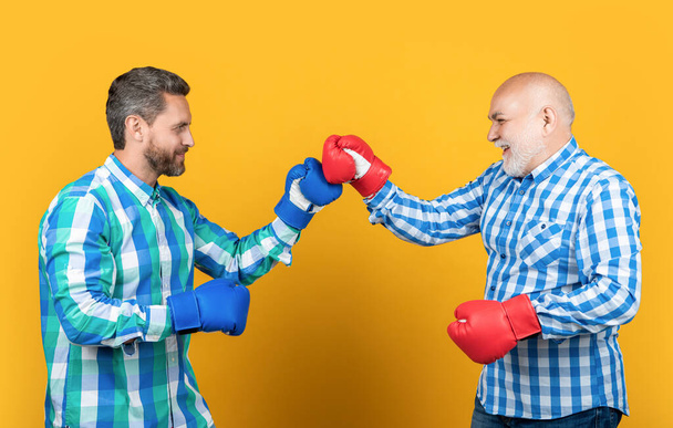 image of generation men boxing wear checkered shirt. two generation men boxing isolated on yellow. generation men boxing in studio. generation men boxing on background. - Fotoğraf, Görsel