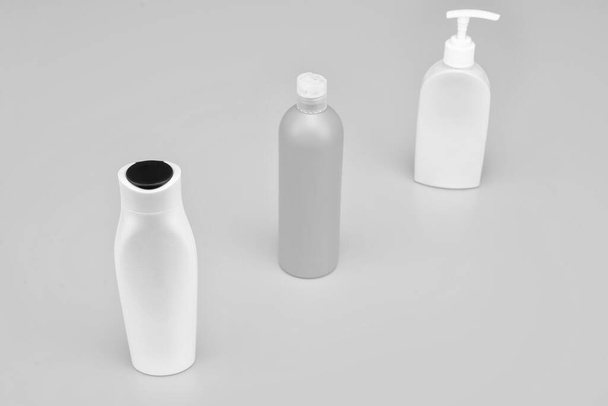 Conveniently shaped containers. Cosmetic bottles in row. Refillable bottles yellow background. Beauty products packing. For storing toiletries, copy space. - Φωτογραφία, εικόνα