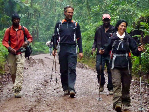 July 22, 2022, Tanzania, Africa: Black local men and tourists walking on the jungle road and smiling - Fotoğraf, Görsel
