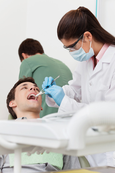 Dentist working on patient's teeth - Foto, imagen
