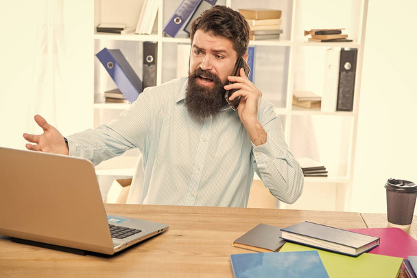 Stressed manager yelling on mobile phone working on laptop in office, stress. - Photo, Image