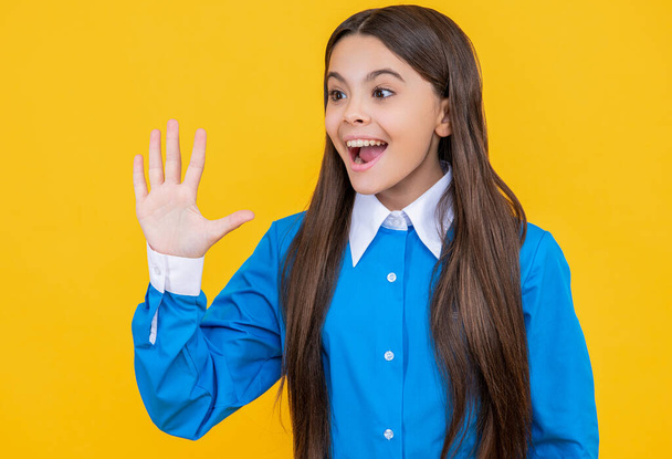 teen school girl in studio, hello. teen school girl on background. photo of teen school girl wearing uniform. teen school girl isolated on yellow. - Фото, изображение