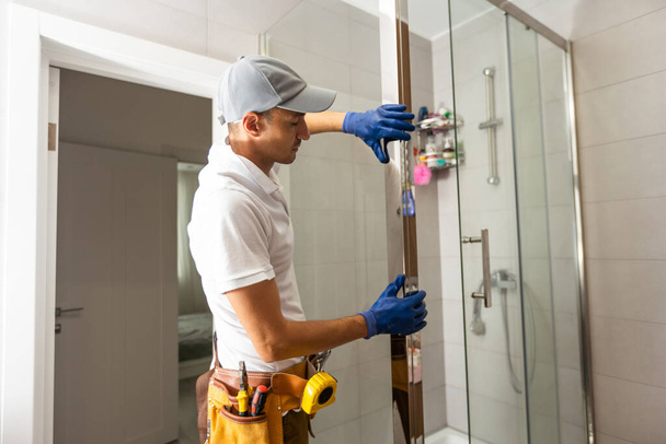 Pracovníci instalují skleněné dveře sprchového koutu. - Fotografie, Obrázek
