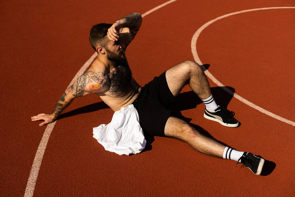Молодой спортсмен отдыхает после тренировки. Фитнес, спорт и стиль жизни. - Фото, изображение