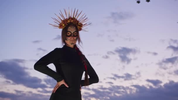 Ευτυχισμένη νεαρή γυναίκα με αποκριάτικη στολή και μακιγιαζ χορεύει στη φύση κατά τη διάρκεια του ηλιοβασιλέματος, μυστικιστικό υλικό - Πλάνα, βίντεο