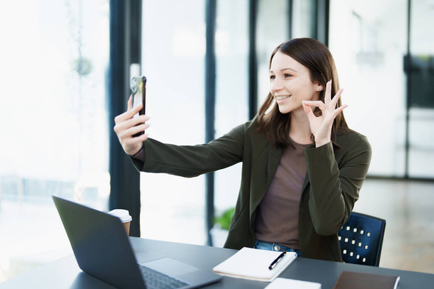 ιδιοκτήτης επιχείρησης ή ασιατικές γυναίκες έμποροι χρησιμοποιούν τα τηλέφωνα των επιχειρήσεων στην εργασία γραφείου. - Φωτογραφία, εικόνα