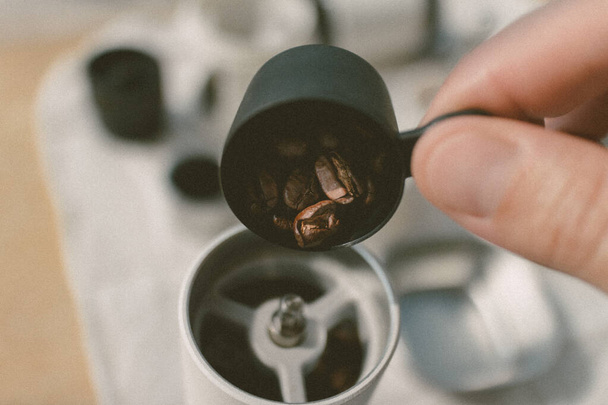 Close up of hand holding a scoop pouring coffee bean into the blender. - Photo, Image