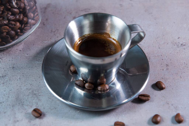Kuuma Espresso palvelee kahvikuppi lusikka ja pavut puolella näkymä harmaa tausta - Valokuva, kuva