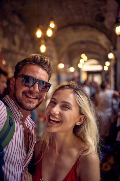 Couple taking selfie at street shop. Tourists on vacation walking through street bazar. Holiday, fun, shopping, lifestyle concept. - Foto, Bild